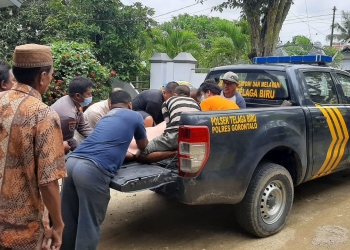Petugas Polsek Telaga Biru mengevakuasi jenazah korban dari kolam pemandian Pentadio Resor menuju ke rumah duka. (istimewa)