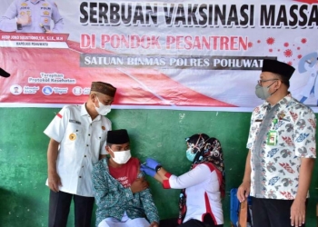 Bupati Pohuwato, Saipul Mbuinga pada saat melakukan peninjauan vaksinasi massal yang digelar oleh Satuan Binmas Pohuwato, di Aula MTs Alkhairaat Paguat. (Foto Istimewa)