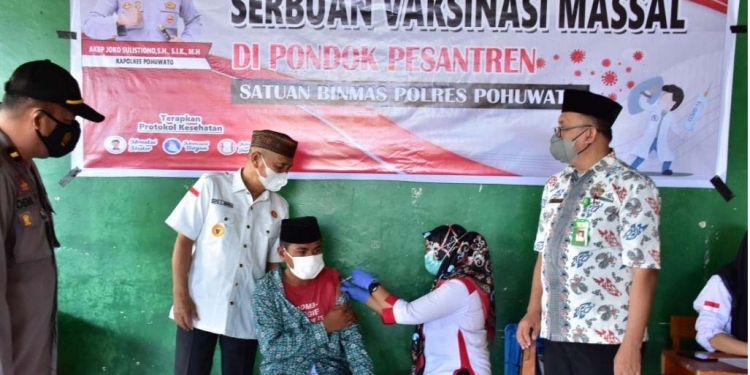 Bupati Pohuwato, Saipul Mbuinga pada saat melakukan peninjauan vaksinasi massal yang digelar oleh Satuan Binmas Pohuwato, di Aula MTs Alkhairaat Paguat. (Foto Istimewa)
