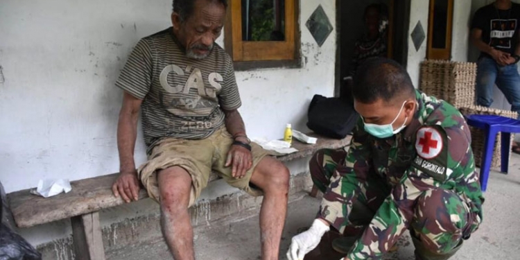 Serka Firman saat mengobati luka seorang kakek, Haryn Kalami, warga Desa Tulabolo, Kecamatan Suwawa Timur, Kabupaten Bone Bolango, yang mengalami terpeleset ke dalam jurang ketika perjalanan menuju ke kebun. (Foto: Istimewa)