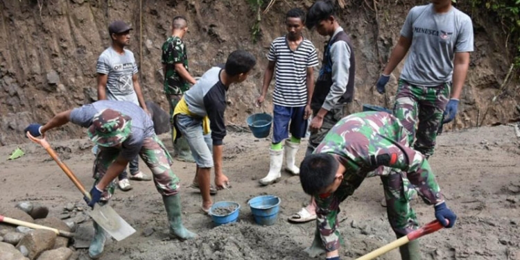 Satgas TMMD ke-112 Kodim 1304/Gorontalo bersama warga terus mempercepat pengecoran jalan rabat beton yang berada di Desa Tulabolo Kecamatan Suwawa Timur Kabupaten Bone Bolango, Minggu (19/9/2021). (Foto Istimewa)