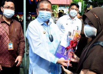 Wagub Gorontalo Idris Rahim, berbincang dengan seorang siswa yang mengikuti vaksinasi Covid-19 di SMP Negeri 1 Kabila, Kabupaten Bone Bolango, Kamis (2/9/2021). (Foto: Haris)