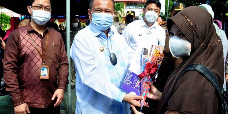 Wagub Gorontalo Idris Rahim, berbincang dengan seorang siswa yang mengikuti vaksinasi Covid-19 di SMP Negeri 1 Kabila, Kabupaten Bone Bolango, Kamis (2/9/2021). (Foto: Haris)