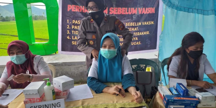 Kompol Sudarsih yang tak canggung memijat para tenaga medis yang menjalankan tugas saat serbuan vaksinasi di Kawasan Center Point. (Foto Indra/Gopos)