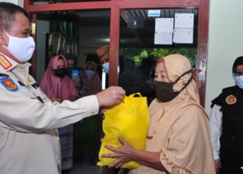 Wagub Gorontalo H. Idris Rahim (kiri), menyerahkan bingkisan kepada seorang warga yang mengikuti vaksinasi door to door yang digelar oleh Kominda Gorontalo di Desa Bongo, Kecamatan Batudaa Pantai, Kabupaten Gorontalo, Rabu (15/9/2021). (Foto : Haris)