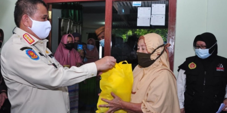 Wagub Gorontalo H. Idris Rahim (kiri), menyerahkan bingkisan kepada seorang warga yang mengikuti vaksinasi door to door yang digelar oleh Kominda Gorontalo di Desa Bongo, Kecamatan Batudaa Pantai, Kabupaten Gorontalo, Rabu (15/9/2021). (Foto : Haris)