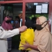 Wagub Gorontalo H. Idris Rahim (kiri), menyerahkan bingkisan kepada seorang warga yang mengikuti vaksinasi door to door yang digelar oleh Kominda Gorontalo di Desa Bongo, Kecamatan Batudaa Pantai, Kabupaten Gorontalo, Rabu (15/9/2021). (Foto : Haris)