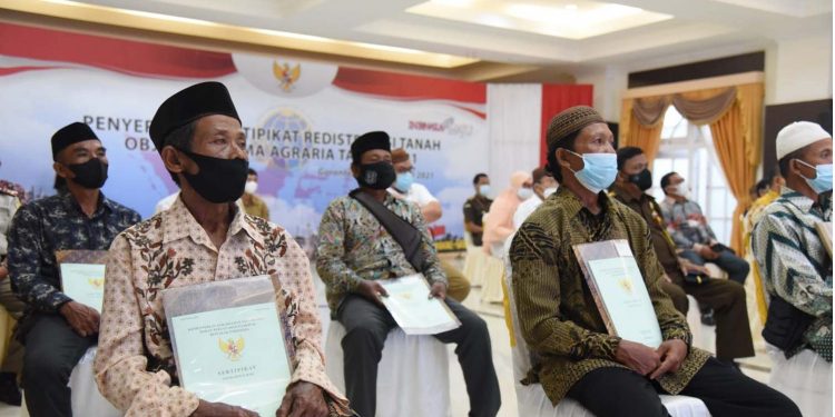 Perwakilan masyarakat penerima sertifikat tanah hasil redistribusi Tanah Objek Reforma Agraria (TORA), usai menghadiri penerimaan sertifikat yang diserahkan Presiden Joko Widodo secara virtual,  Rabu (22/9/2021). (Foto: Salman)