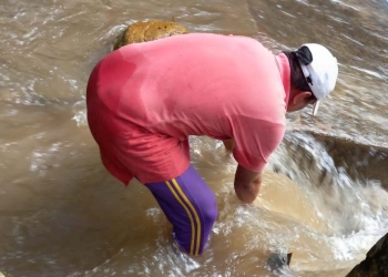 Tenaga teknis dari Perumda Tirta Bulango, saat membersihkan bak penampungan di Desa Lombongo yang dipenuhi pasir dan lumpur, yang mengakibatkan gangguan layanan air bersih untuk masyarakat. (Foto Istimewa)
