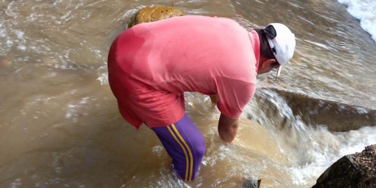 Tenaga teknis dari Perumda Tirta Bulango, saat membersihkan bak penampungan di Desa Lombongo yang dipenuhi pasir dan lumpur, yang mengakibatkan gangguan layanan air bersih untuk masyarakat. (Foto Istimewa)
