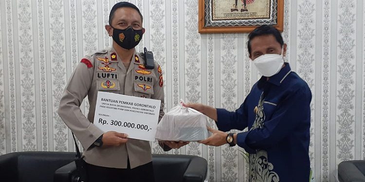 DANA COVID-Bupati Gorontalo, Nelson Pomalingo (kanan) saat memberikan dana penanganan Covid-19 untuk para kepolisian kepada Wakapolres Gorontalo, Kompol Lufti Amir (kiri), di Ruang Kerja Bupati Gorontalo, Kamis (14/10/2021). Humas Kominfo Kabupaten Gorontalo.