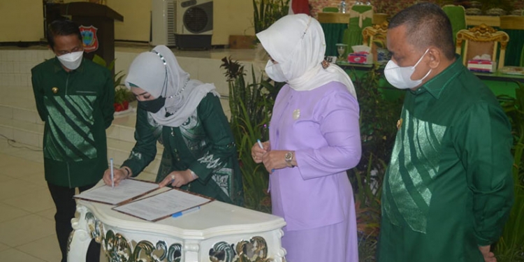 DEKRANASDA KABUPATEN GORONTALO - Ketua Dekranasda Kabupaten Gorontalo, Forry Naway saat menandatangani naskah pelantikan pengurus Dekranasda Kabupaten Gorontalo bersama Ketua Dekranasda Provinsi Gorontalo, Idah Syaidah Rusli Habibie ditemani Bupati dan Wakil Bupati Gorontalo di Gedung Kasmat Lahay, Kecamatan Limboto, Kabupaten Gorontalo, Senin (11/10/2021). Foto : Putra/Gopos.