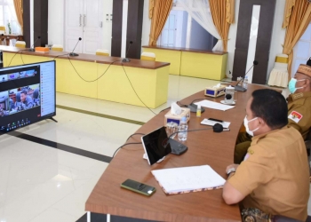 Gubernur Gorontalo Rusli Habibie didampingi Kaban Keuangan Daniel Ibrahim saat mengikuti rapat paripurna DPRD Provinsi Gorontalo ke-69, yang berlangsung secara virtual, Senin (4/10/2021). (Foto: Salman)