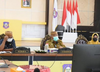 Gubernur Gorontalo Rusli Habibie (tengah) didampingi Sekretaris Daerah Darda Daraba (kiri) dan Kepala Dinas Kesehatan Provinsi Gorontalo Yana Yanti Suleman (kanan) saat mengikuti Rapat Evaluasi PPKM dan vaksinasi yang diperluas bersama forkompinda secara virtual di Rujab Gubernur,  Selasa (19/10/2021). (foto : Salman)