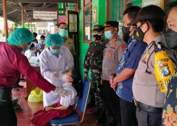 Forkopimcam Kauman Tulungagung saat mengawal swab antigen siswa SD di Kecamatan Kauman, Kabupaten Tulungagung, Selasa (12/10/2021). (Foto: dok. Polres Tulungagung)