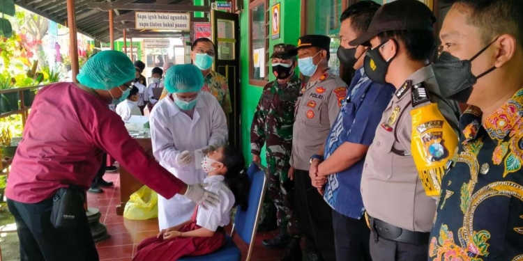 Forkopimcam Kauman Tulungagung saat mengawal swab antigen siswa SD di Kecamatan Kauman, Kabupaten Tulungagung, Selasa (12/10/2021). (Foto: dok. Polres Tulungagung)