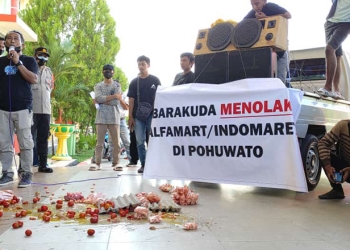 Massa aksi menghambur tomat dan telur di depan kantor Bupati Pohuwato sebagai bentuk protes terhadap kehadiran Alfamaret dan Indomaret di Pohuwato, Selasa (26/10/2021). (Mahmud/gopos)