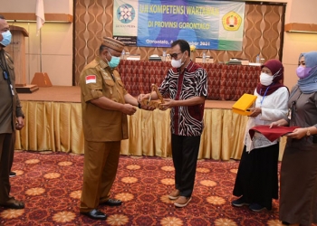 ubernur Gorontalo Rusli Habibie menerima cindera mata dari
Ketua Jurusan Ilmu Komunikasi Agung Prabowo usai membuka UKW gratis fasilitas Dewan Pers di Hotel Maqna Gorontalo.