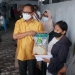 Irwan Hunawa, sedang menyerahkan bantuan berupa beras kepada peserta yang telah divaksin Covid-19, Senin (11/10/2021). (Foto: Humas Dekot)