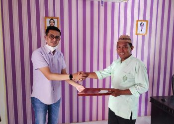 Dosen Fakultas Hukum UNG, Novendri M. Nggilu, SH., MH, menyerahkan rancangan peraturan desa tentang desa bersinar, Kamis (21/10/2021) (istimewa)