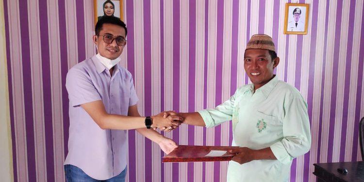Dosen Fakultas Hukum UNG, Novendri M. Nggilu, SH., MH, menyerahkan rancangan peraturan desa tentang desa bersinar, Kamis (21/10/2021) (istimewa)