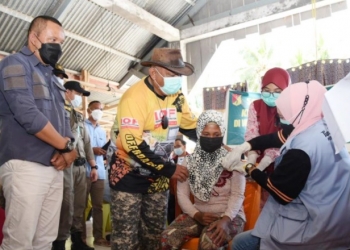 Gubernur Gorontalo Rusli Habibie menyapa langsung warga yang melakukan vaksinasi di Desa Pangi, Minggu (17/10/2021). Usai dari dari Pangi, perjalanan Rusli dan offroader lain akan berlanjut ke Desa Tangga Barito tepatnya di Dusun Molili’ulo. (Foto: Salman).