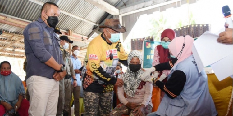 Gubernur Gorontalo Rusli Habibie menyapa langsung warga yang melakukan vaksinasi di Desa Pangi, Minggu (17/10/2021). Usai dari dari Pangi, perjalanan Rusli dan offroader lain akan berlanjut ke Desa Tangga Barito tepatnya di Dusun Molili’ulo. (Foto: Salman).