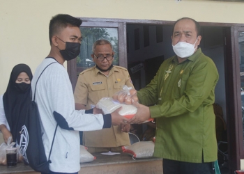 Ketua DPRD Kabupaten Bone Bolango Halid Tangahu saat memberikan bantuan kepada masyarakat usai melaksanakan vaksinasi di Kantor DPRD Kabupaten Bone Bolango. Senin (4/10/2021). (Foto: Putra/gopos)