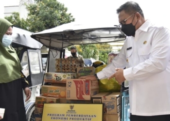 Wali Kota Gorontalo, Marten Taha saat menyerahkan bantuan Modal kepada pelaku UMKM. Foto (Diskominfo Kota Gorontalo