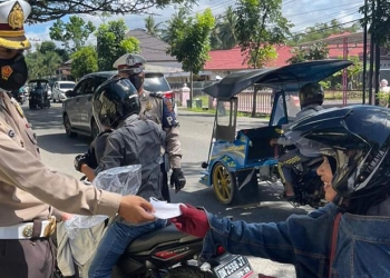 Personel Dit Lantas Polda Gorontalo membagikan masker kepada pengendara yang tidak menggunakan masker. Langkah ini dilakukan sebagai bentuk meningkatkan kepatuhan masyarakat terhadap prokes pencegahan Covid-19. (istimewa)