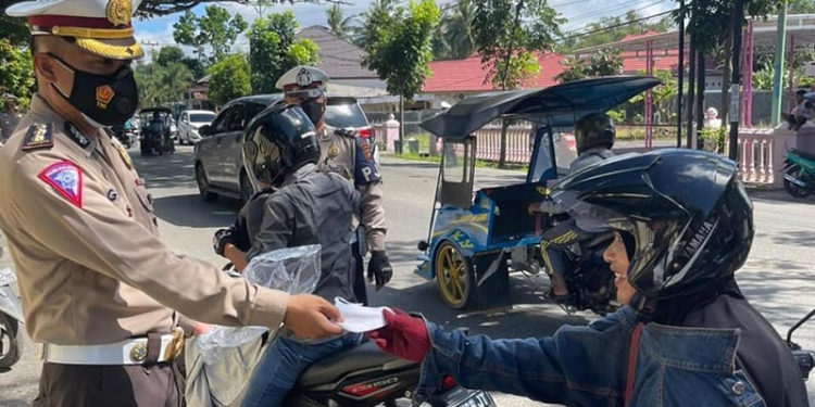 Personel Dit Lantas Polda Gorontalo membagikan masker kepada pengendara yang tidak menggunakan masker. Langkah ini dilakukan sebagai bentuk meningkatkan kepatuhan masyarakat terhadap prokes pencegahan Covid-19. (istimewa)