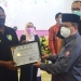 Wakil Gubernur Gorontalo, Idris Rahim saat menyerahkan penghargaan kepada salah satu elemen kesehatan di Provinsi Gorontalo di  peringatan HKN Ke-57 di Grand Sumberia Ballroom, Jumat (12/11/2021). (Foto : Putra/Gopos)