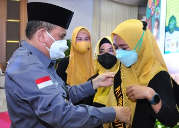 Wagub Gorontalo H. Idris Rahim (kiri) menyerahkan penghargaan dan hadiah kepada Tenaga Kesehatan Teladan pada puncak peringatan HKN ke-57 tingkat Provinsi Gorontalo di Gedung Grand Sumber Ria, Kota Gorontalo, Jumat (12/11/2021). (Foto: Haris)