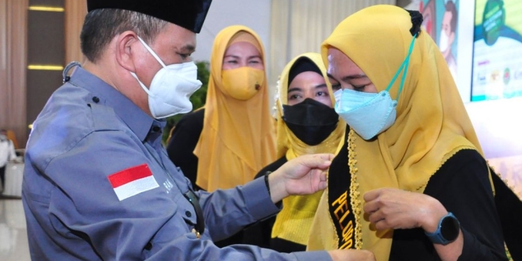 Wagub Gorontalo H. Idris Rahim (kiri) menyerahkan penghargaan dan hadiah kepada Tenaga Kesehatan Teladan pada puncak peringatan HKN ke-57 tingkat Provinsi Gorontalo di Gedung Grand Sumber Ria, Kota Gorontalo, Jumat (12/11/2021). (Foto: Haris)