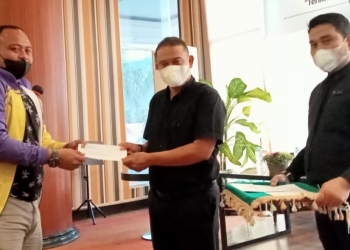 Nikson Tahir (tengah), Direktur operasional Grand Q Hotel, sedang menyerahkan hadiah berupa voucher menginap kepada atlet penyumbang medali emas  cabang olahraga sepak takraw, PON XX Papua, Kamis (11/11/2021). (Foto: Sari/gopos)