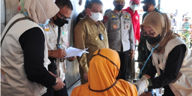 Wagub Gorontalo Idris Rahim (tengah) bersama Kapolda Gorontalo Irjen Pol. Akhmad Wiyagus meninjau vaksinasi dari rumah ke rumah yang dilaksanakan oleh Binda Provinsi Gorontalo di Desa Bajo, Kecamatan Tilamuta, Kabupaten Boalemo, Selasa (23/11/2021). (Foto : Haris)