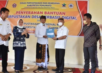 Bupati Pohuwato, Saipul Mbuinga saat menyerahkan bantuan perpustakaan desa berbasis digital, Rabu (24/11/2021). (Foto istimewa)