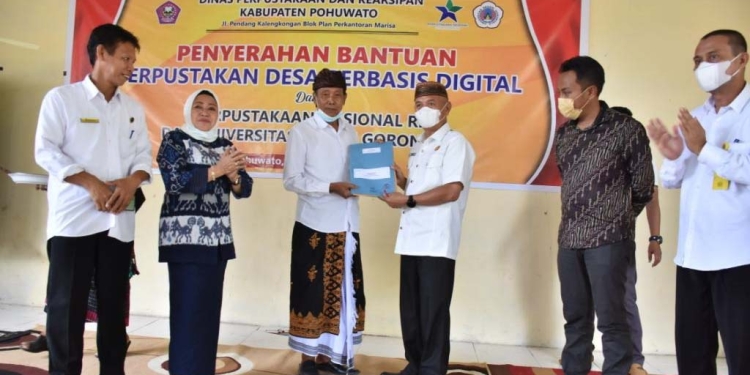 Bupati Pohuwato, Saipul Mbuinga saat menyerahkan bantuan perpustakaan desa berbasis digital, Rabu (24/11/2021). (Foto istimewa)