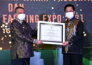 Wakil Gubernur Gorontalo, Idris Rahim saat menyerahkan penghargaan Adhikarya Ketahanan Pangan tingkat Provinsi Gorontalo kepada Kepala KPwBI Gorontalo, Budi Widihartanto, sebagai pelopor dalam mewujudkan ketahanan, kemandirian, dan kedaulatan pangan, Kamis (16/12/2021). (Foto: Haris)