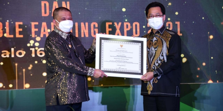 Wakil Gubernur Gorontalo, Idris Rahim saat menyerahkan penghargaan Adhikarya Ketahanan Pangan tingkat Provinsi Gorontalo kepada Kepala KPwBI Gorontalo, Budi Widihartanto, sebagai pelopor dalam mewujudkan ketahanan, kemandirian, dan kedaulatan pangan, Kamis (16/12/2021). (Foto: Haris)