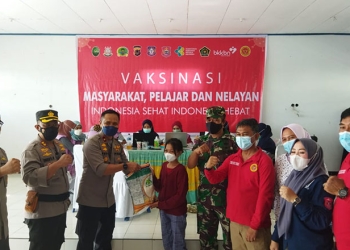 Wakapolda Gorontalo, Brigjen Pol Pudji Prasetijanto memberikan sembako kepada pelajar usai mengikuti vaksinasi di wilayah pesisir yang dilaksanakan BINDA Gorontalo bekerja sama Polri dan TNI di wilayah Bonepesisir, Kamis (9/12/2021). (istimewa)