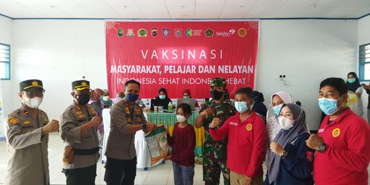 Wakapolda Gorontalo, Brigjen Pol Pudji Prasetijanto memberikan sembako kepada pelajar usai mengikuti vaksinasi di wilayah pesisir yang dilaksanakan BINDA Gorontalo bekerja sama Polri dan TNI di wilayah Bonepesisir, Kamis (9/12/2021). (istimewa)