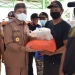 Bupati Pohuwato, Saipul Mbuinga, menyerahkan bantuan banjir rob kepada warga yang terdampak bencana banjir rob. (istimewa)