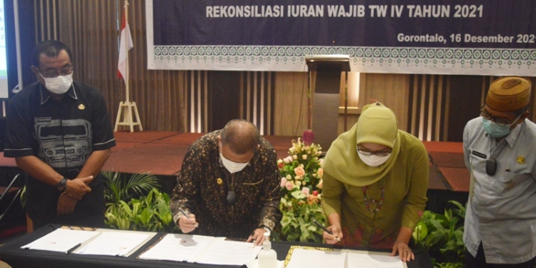 Penandatanganan NK dan RK PBPU BP Pemerintah Daerah Kabupaten/Kota se-Provinsi Gorontalo Tahun 2022 dirangkaikan rekonsiliasi iuran wajib TW IV tahun 2021 oleh Wakil Gubernur Gorontalo. Idris Rahim (Kiri) bersama Deputi Direksi BPJS Wilayah Suluttenggo, dr. Medianti Ellya Permatasari, di Hotel Aston, Kota Gorontalo, Kamis (16/12/2021). (Foto: Putra/Gopos)