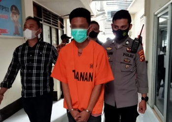 Pelaku penikaman terhadap seorang pemuda, FM, di Jl. Andalas, MRGB alias Gilang dikawal petugas Polres Gorontalo Kota, Selasa (7/12/2021). (sari/gopos)