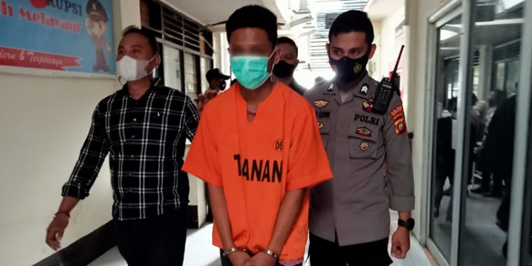 Pelaku penikaman terhadap seorang pemuda, FM, di Jl. Andalas, MRGB alias Gilang dikawal petugas Polres Gorontalo Kota, Selasa (7/12/2021). (sari/gopos)