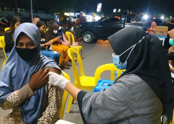 Salah seorang pengunjung objek wisata Pohon Cinta menjalani penyuntikan vaksin  Covid-19, Sabtu (18/12/2021)
