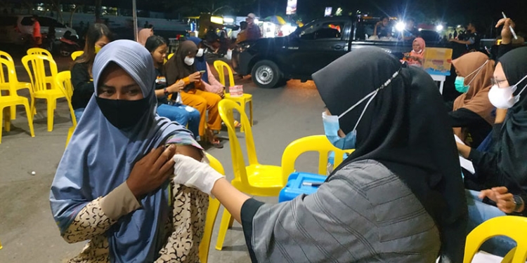 Salah seorang pengunjung objek wisata Pohon Cinta menjalani penyuntikan vaksin  Covid-19, Sabtu (18/12/2021)