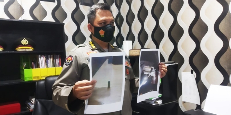 Kabid Humas Polda Gorontalo, Kombes Pol Wahyu Tri Cahyono menunjukkan foto proyektil peluru dan jenis pistol yang diamankan terkait insiden peluru nyasar di Kecamatan Telaga, Kabupaten Gorontalo, Kamis (2/12/2021). (Foto : Putra/Gopos)