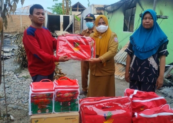 Dinas Sosial Kabupaten Pohuwato, saat memberikan bantuan kepada korban kebakaran di Desa Buntulia Barat, Kecamatan Duhiadaa, Kabupaten Pohuwato, Selasa (07/12/2021). (Foto istimewa).